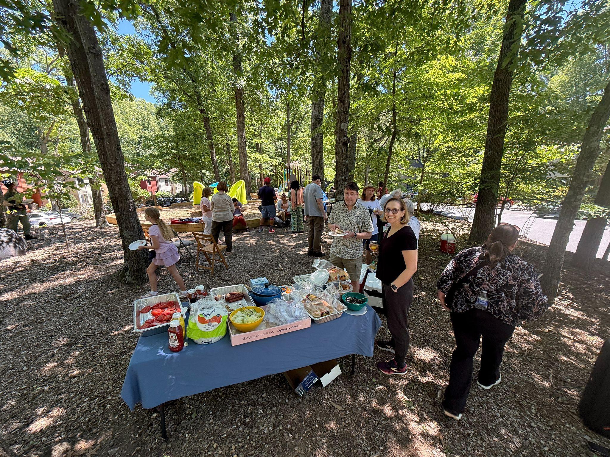 Neighbors gathering around a picnic table at the Soapstone Community Picnic